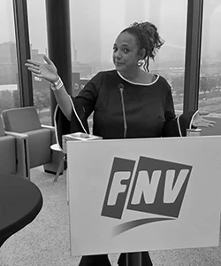 Vrouw spreekt achter FNV-podium met microfoon