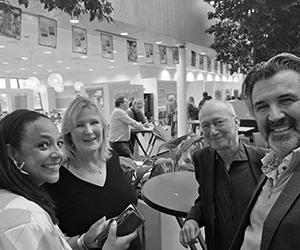 Vier mensen glimlachen in lichte lobby
