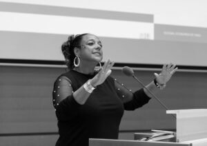 Zwarte vrouw houdt een gepassioneerde toespraak op een podium gissella.nl