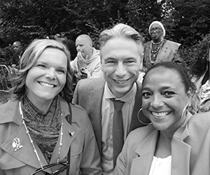 Drie lachende mensen poseren voor selfie buiten
